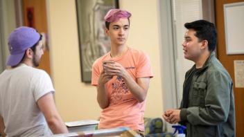 Three students talking at kickoff event