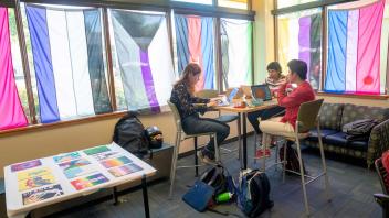 Three students talking at a table