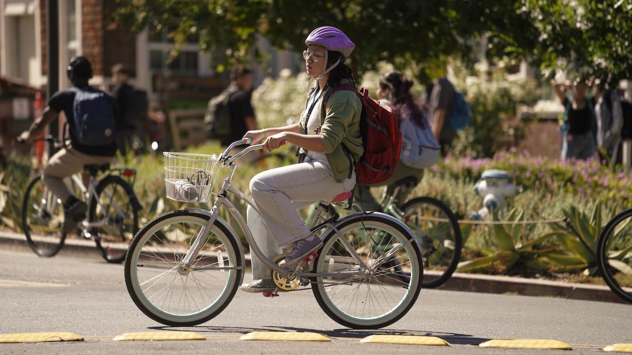 Student riding bike and wearing helmet.