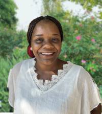 Krystal Oliver, a woman wearing a white blouse smiling directly into the camera for a close-up headshot