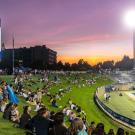 Student watching football game at sunset