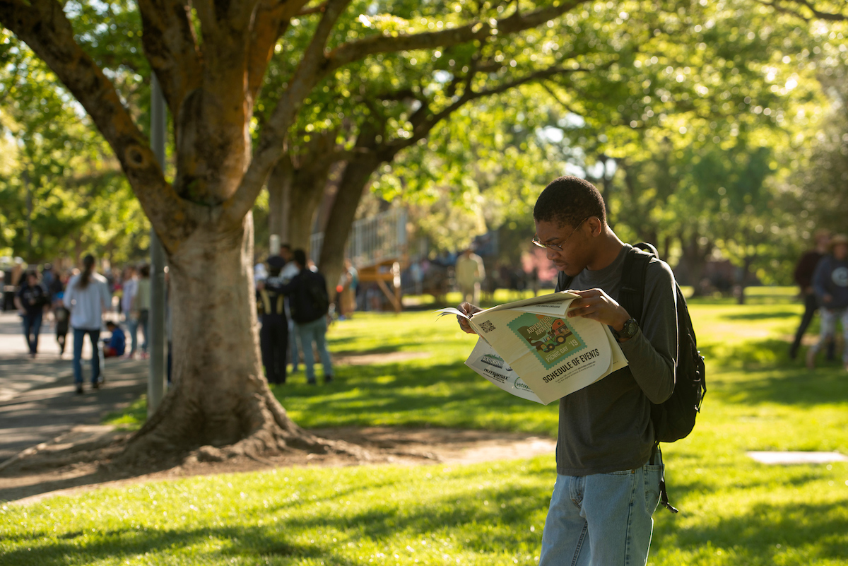 A person reads the 2019 Picnic Day guide