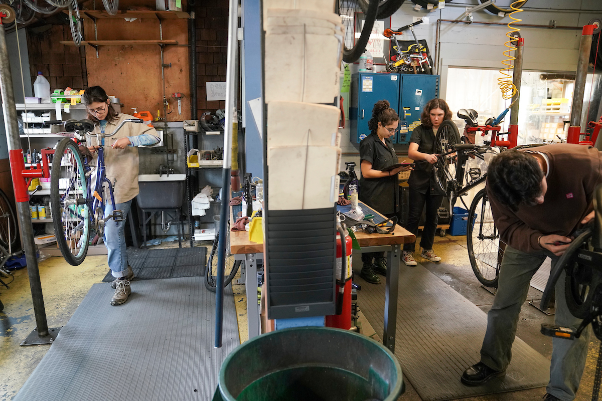 Student bike mechanics work on bikes in the Bike Barn