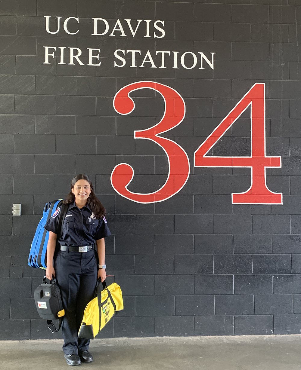 Neha standing in front of fire station wall
