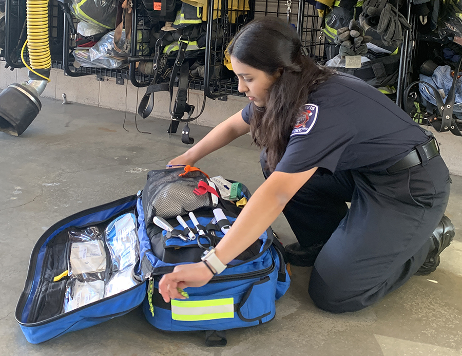 Neha zipping a bag in the fire station