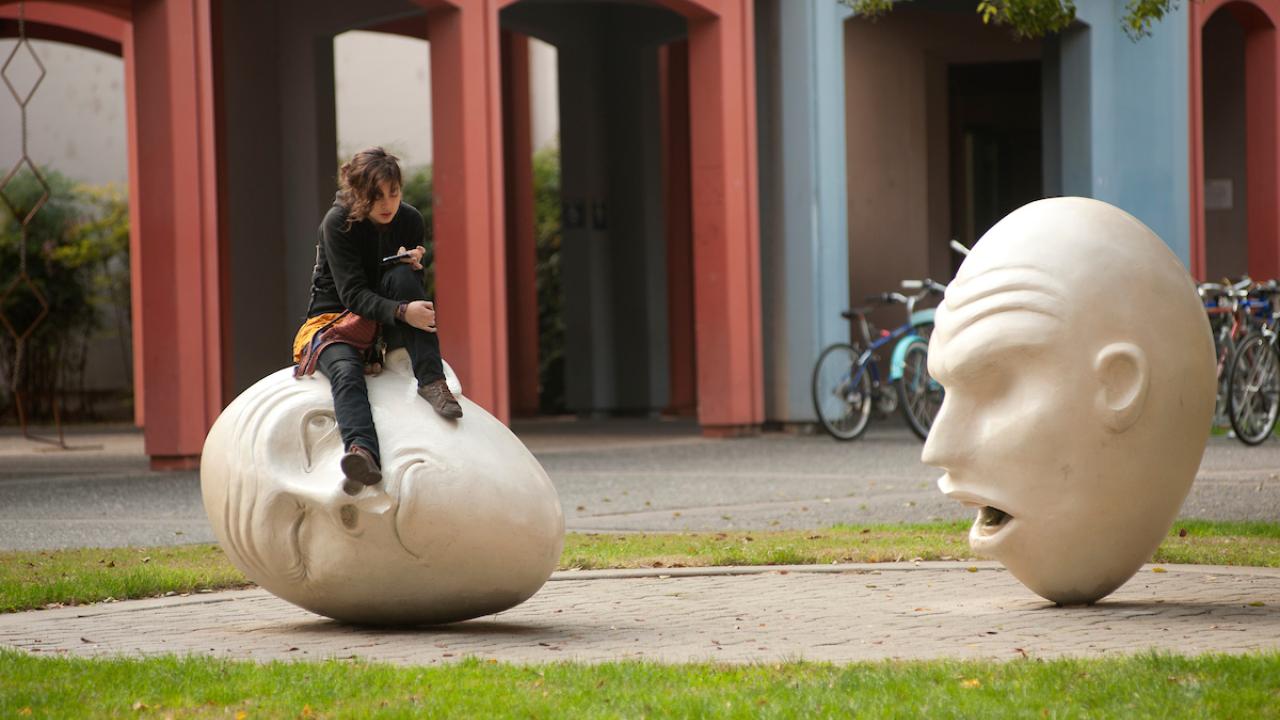 A student sits on a Yin and Yang Egghead