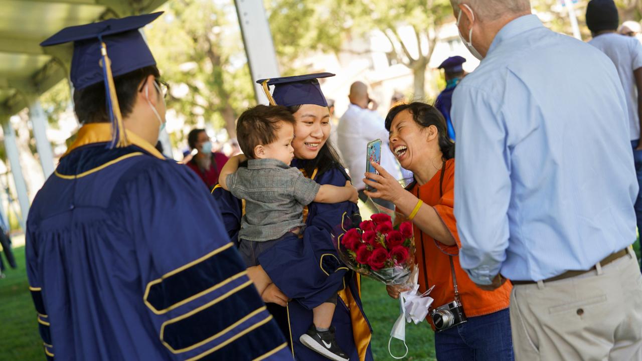 Student with child at Commencement (UC Davis/Karin Higgins)