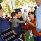 Student with child at Commencement (UC Davis/Karin Higgins)